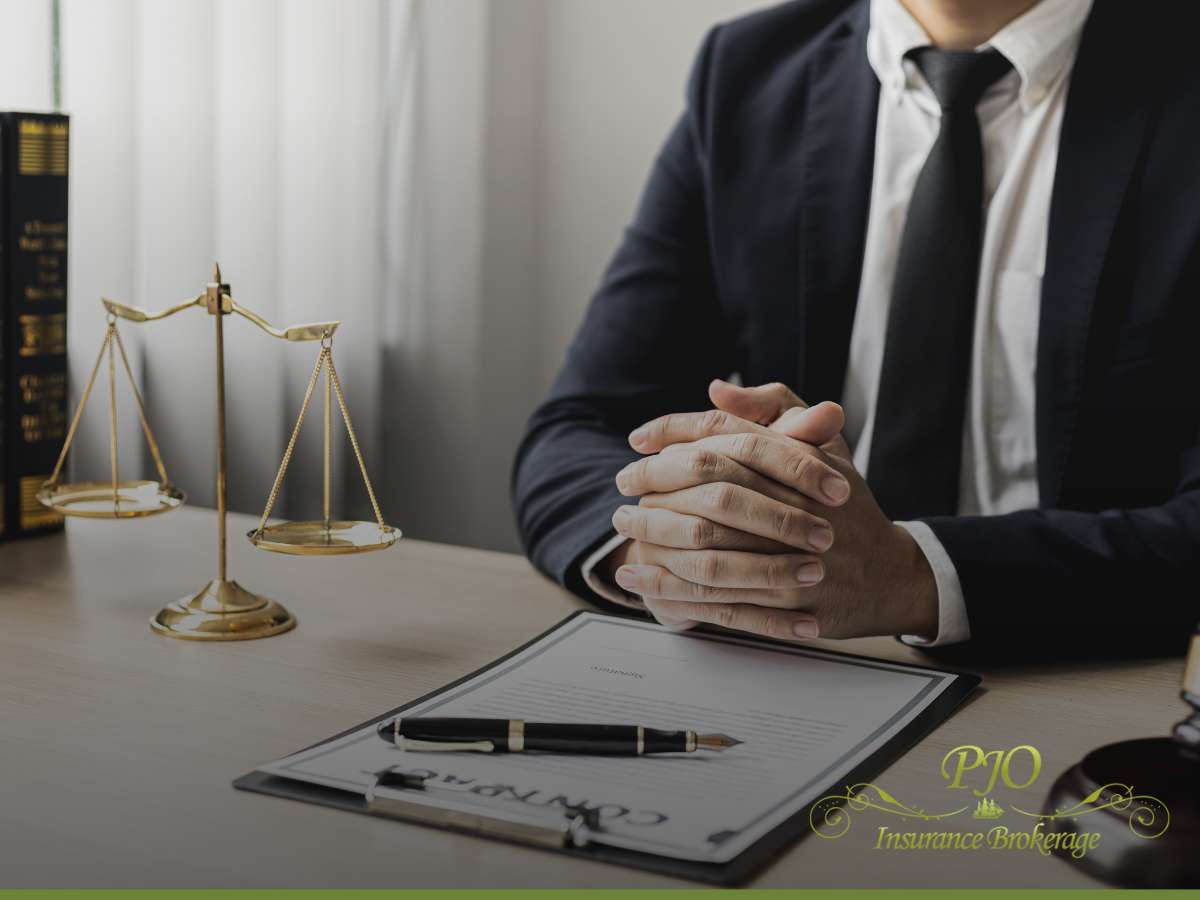 Businessman sitting at a desk with scales of justice and a contract, representing General Liability Insurance