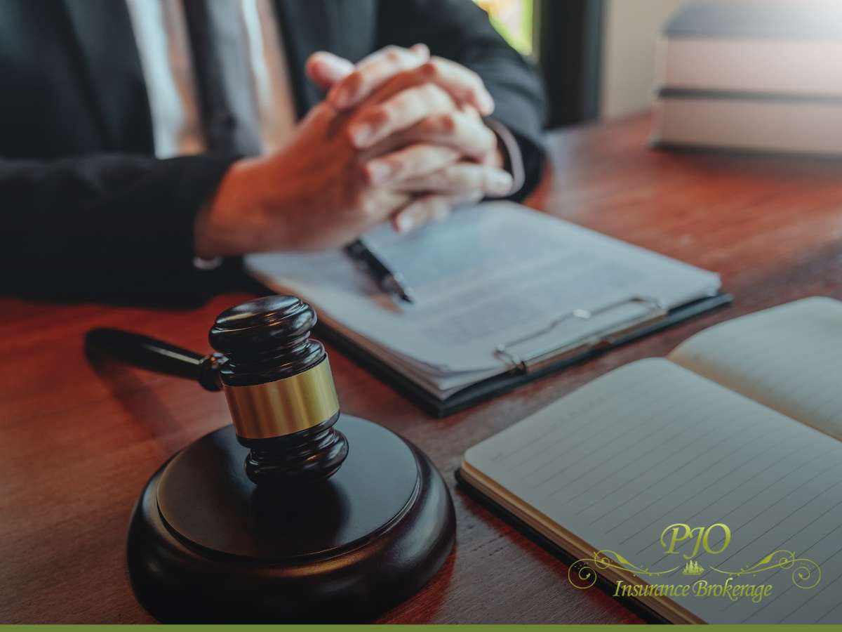 Professional at a desk with legal documents and a gavel, representing expertise in Insurance services at PJO Insurance Brokerage